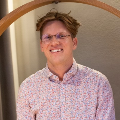 Person in floral shirt, neutral background.