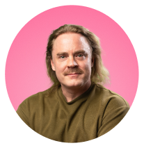 Long-haired man in khaki t-shirt, pink background