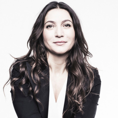 Woman with long wavy hair, blazer.