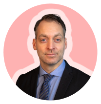 Dark haired man in suit, pink background